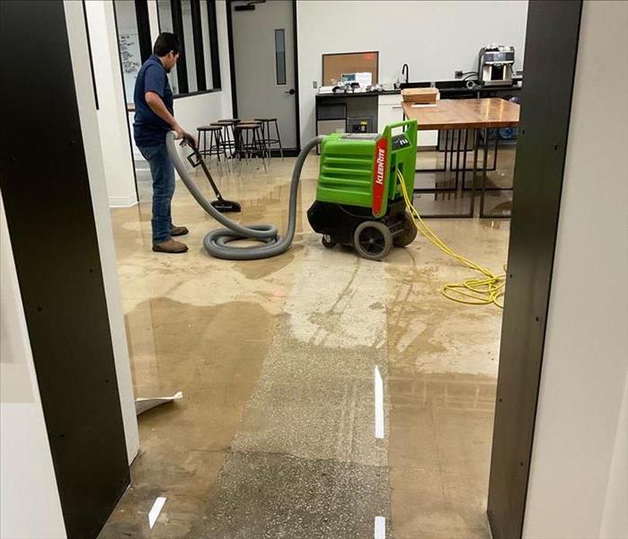 Tech extracting water from floor